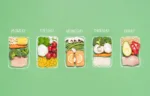 Weekly meal preparation concept with raw food ingredients in chalk-drawn lunch boxes on green background. Prep meals plan for the week. Healthy meals