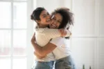 Two female friends happily hugging each other