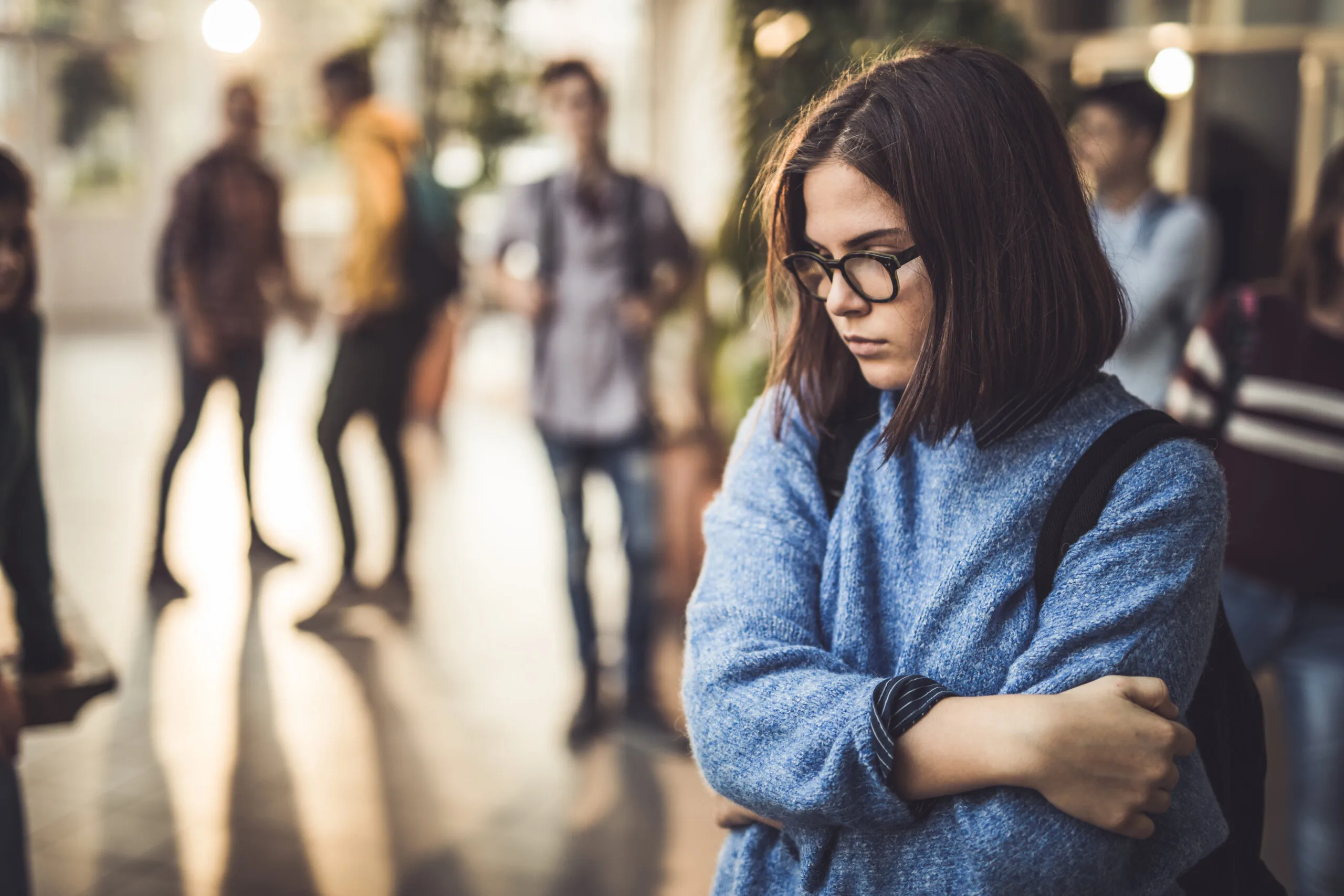 displeased-female-student-bullied-by-her-classmate-standing-alone-in-a-hallway-stockpack-gettyimages-scaled-jpg