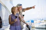 Happy senior couple on a yacht drinking alcohol and mixing it with dramamine