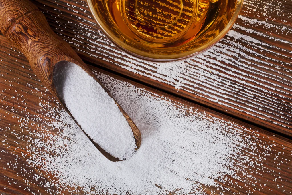 Powdered alcohol dumped onto a table next to a glass filled with alcohol