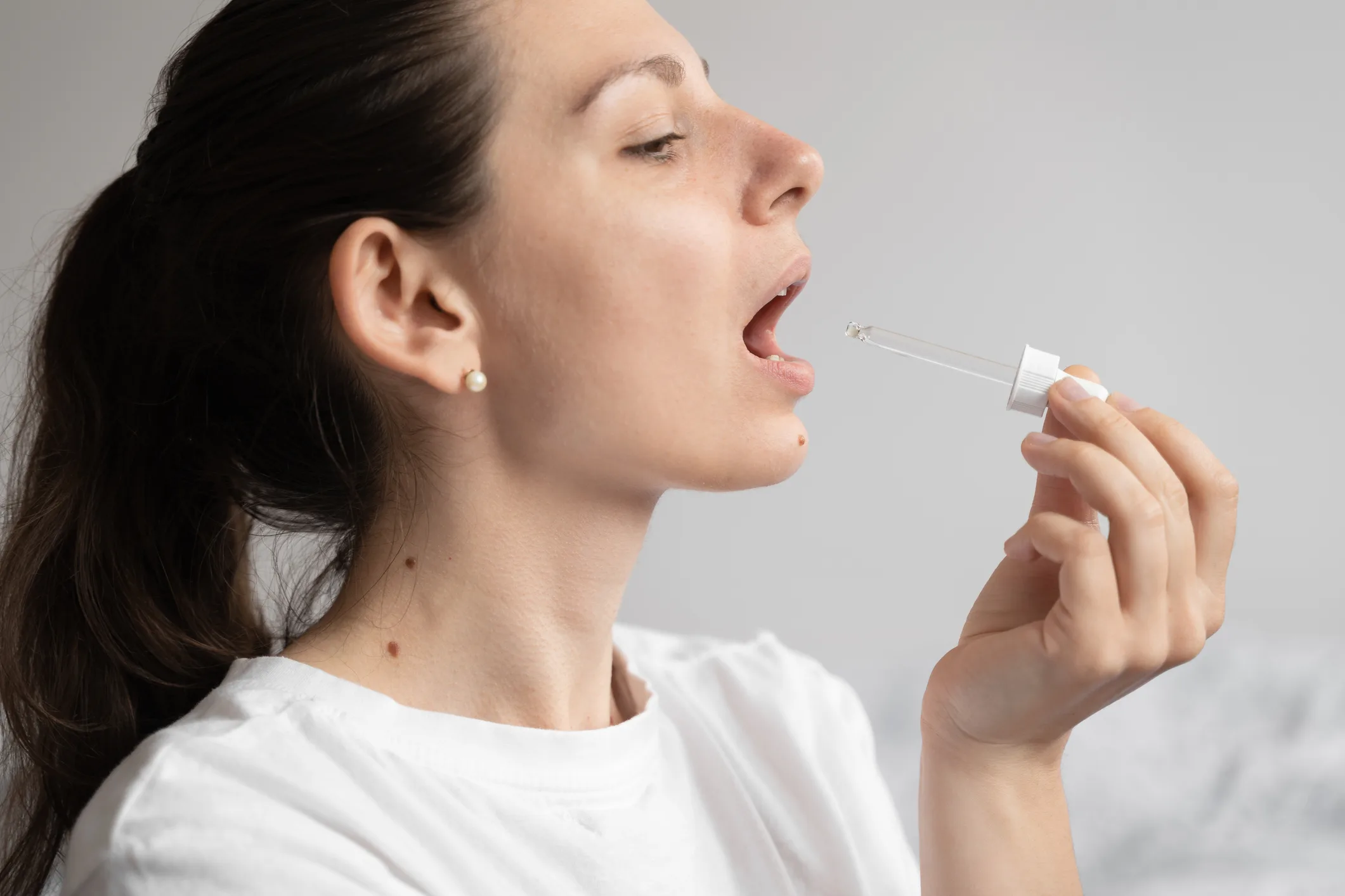 Woman using dropper for microdosing